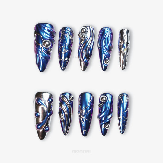 Stellar Ripples press-on nails laid out in close-up, with electric blue chrome, silver metallic detailing, and wave-like futuristic sculpted lines.