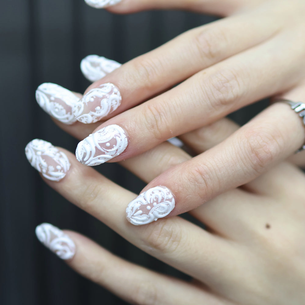 Sugar Carving press-on nails on hand, sheer nude with white lace swirls