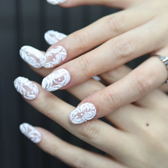 Sugar Carving press-on nails on hand, sheer nude with white lace swirls