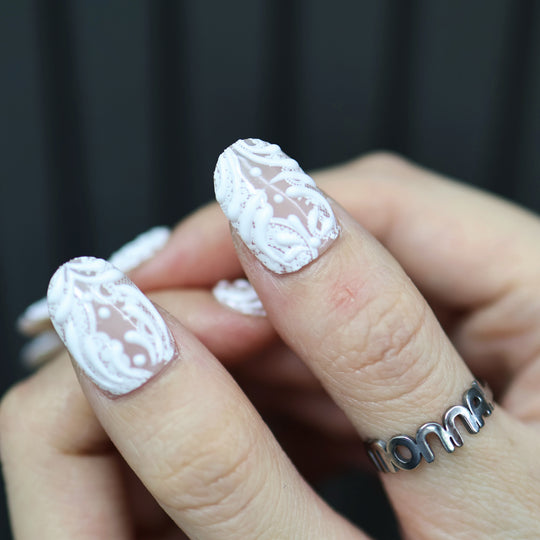 Sugar Carving press-on nails on hand, sheer nude base with white lace and 3D swirl details