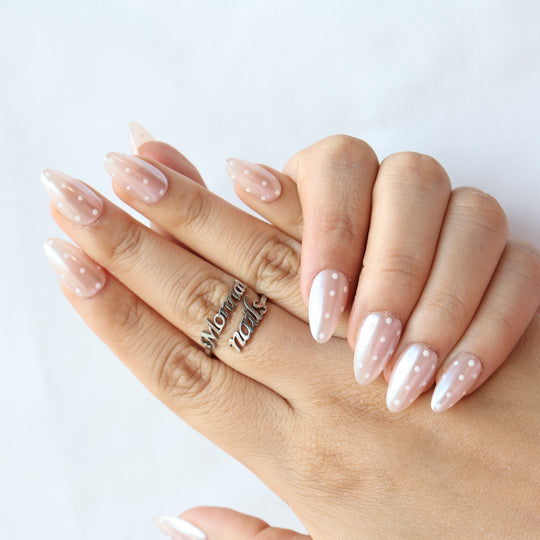 Sugar Glaze press-on nails on hands, sheer champagne pink with white polka dots and pearlescent shimmer