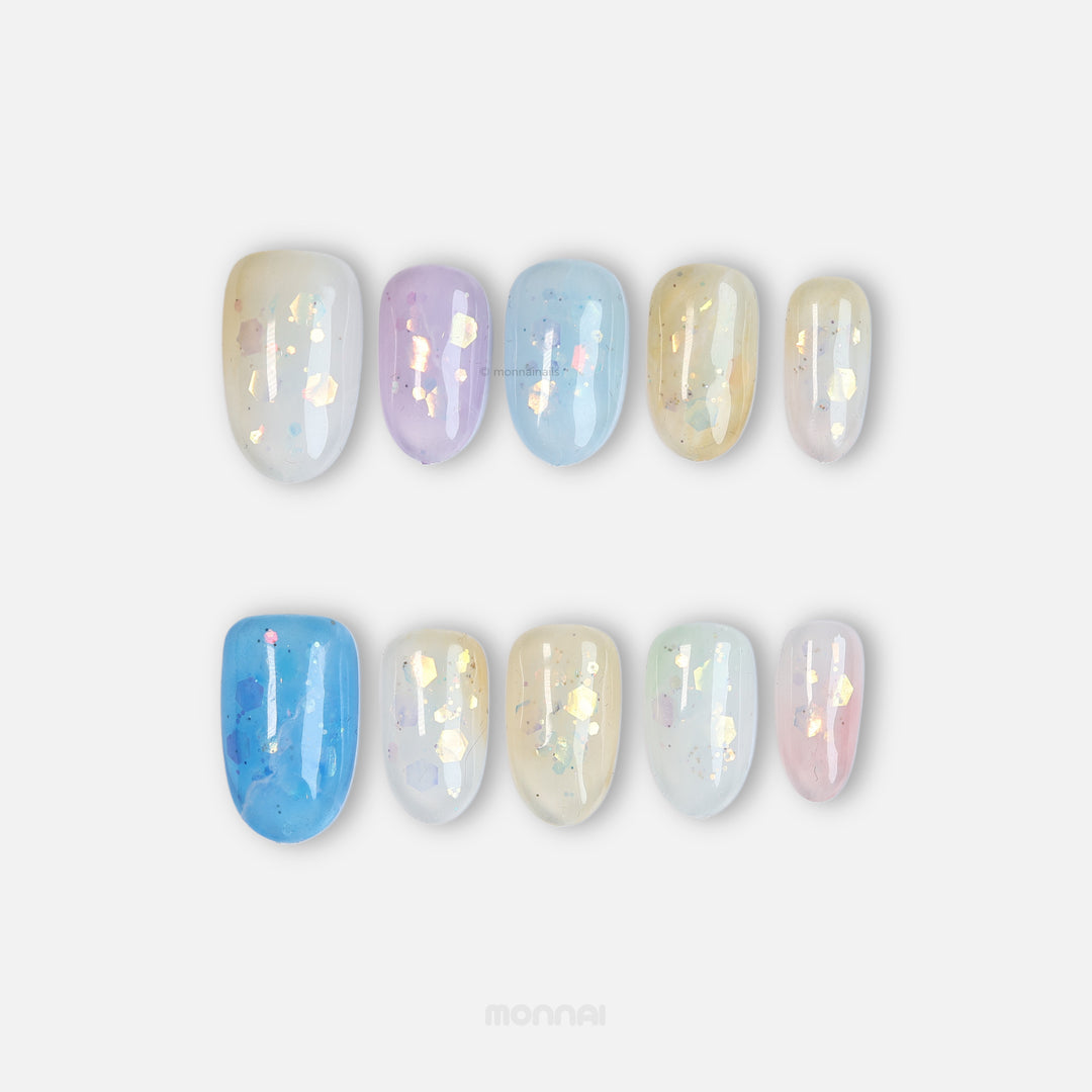 Sugar Sparkle press-on nails in pastel blue, lavender, pink and cream with airy foil accents.