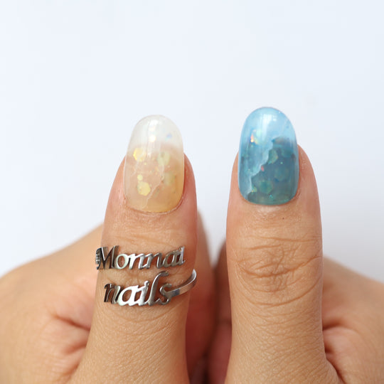 Sugar Sparkle press-on nails shown on hands, with soft pastel shimmer and scattered foil accents in dreamy pastel tones.