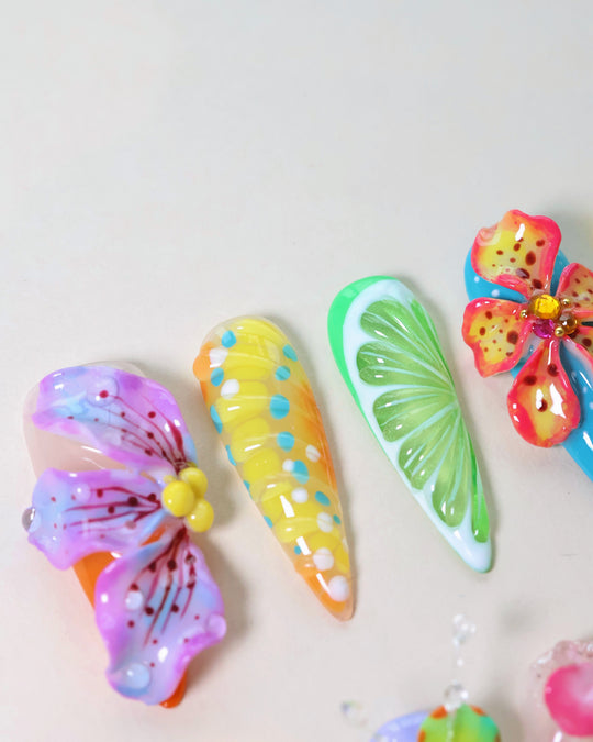 Summer Garden Party press-on nails laid out in close-up with pastel floral, citrus and leaf 3D designs