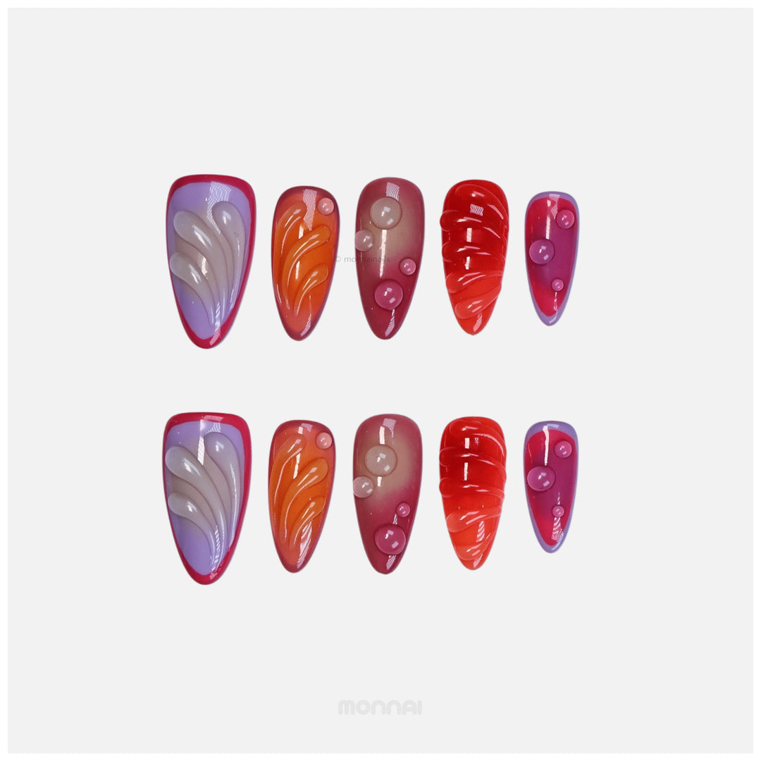 Sunset Flow press-on nails laid out in bold red, purple and orange with glossy bubble accents and sculpted details