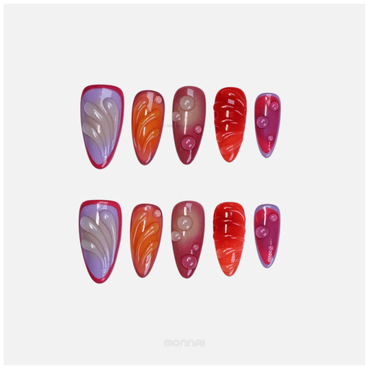Sunset Flow press-on nails laid out in bold red, purple and orange with glossy bubble accents and sculpted details