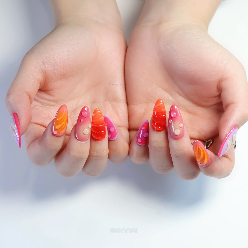 Sunset Flow press-on nails shown on hands, with glossy vivid red and purple bubble accents and sculpted summer tones.