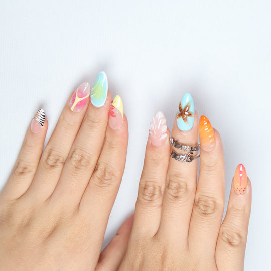The Beach press-on nails worn on hands, showing seafoam blue, sunset gradients, and 3D starfish and shell textures.