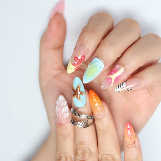 The Beach press-on nails shown on hand, with pastel sea-inspired gradients, 3D starfish texture, shell detail, and glossy finish.