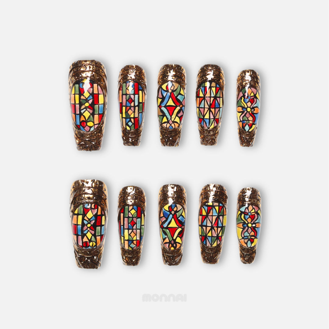 The Fifth Window press-on nails shown in two rows, with colorful cathedral-style stained-glass motifs and bronze frames.