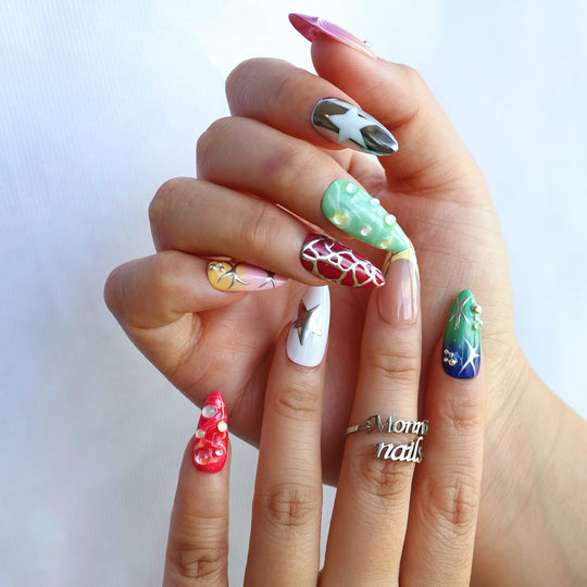 Toxic press-on nails worn on hand, with Y2K chrome stars, liquid metal accents, and vibrant red, green, and white designs