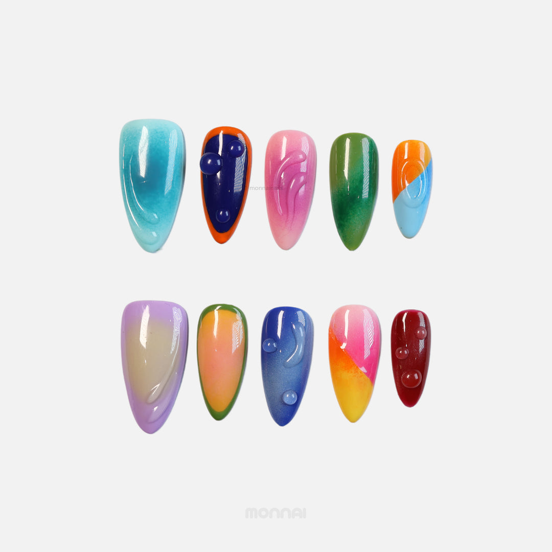 Tropical Vibes press-on nails in colorful mismatched hues with glossy 3D gel accents, laid out on white