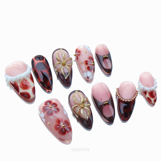 Twilight Shine press-on nails laid out in soft pink, sheer nude, tortoiseshell, floral details and gold accents