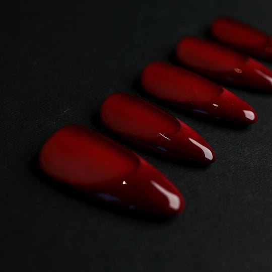 Vampire’s Kiss deep red press-on nails with a high-gloss finish, laid out in close-up.