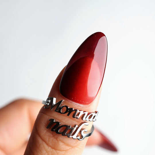 Vampire’s Kiss press-on nails on hand, close-up of a deep red glossy almond nail