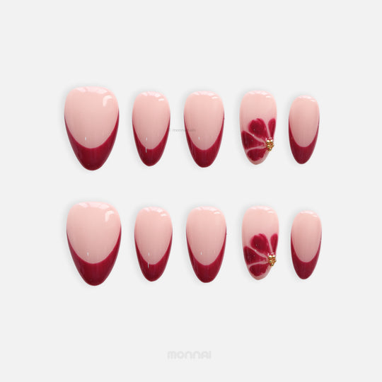 Velvet Petal press-on nails set with sheer nude base, deep burgundy French tips, floral accent and gold studs