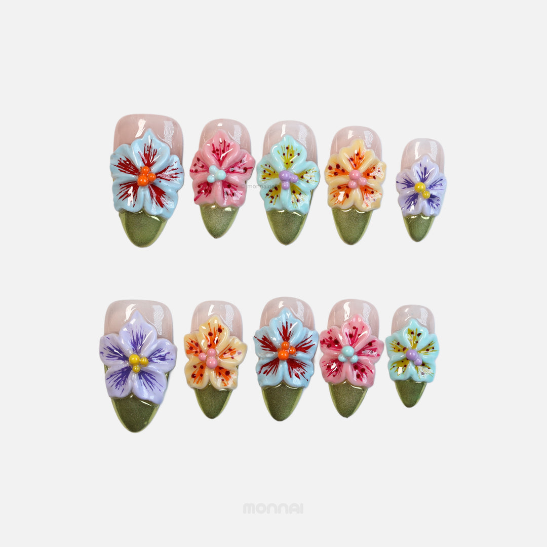 Vibrant Blossoms press-on nails laid out in colorful 3D floral designs with olive green tips.