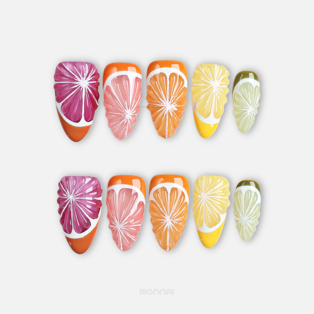 Vitamin C Crew press-on nails laid out with grapefruit, orange, lemon and lime slice designs in bright citrus colors.