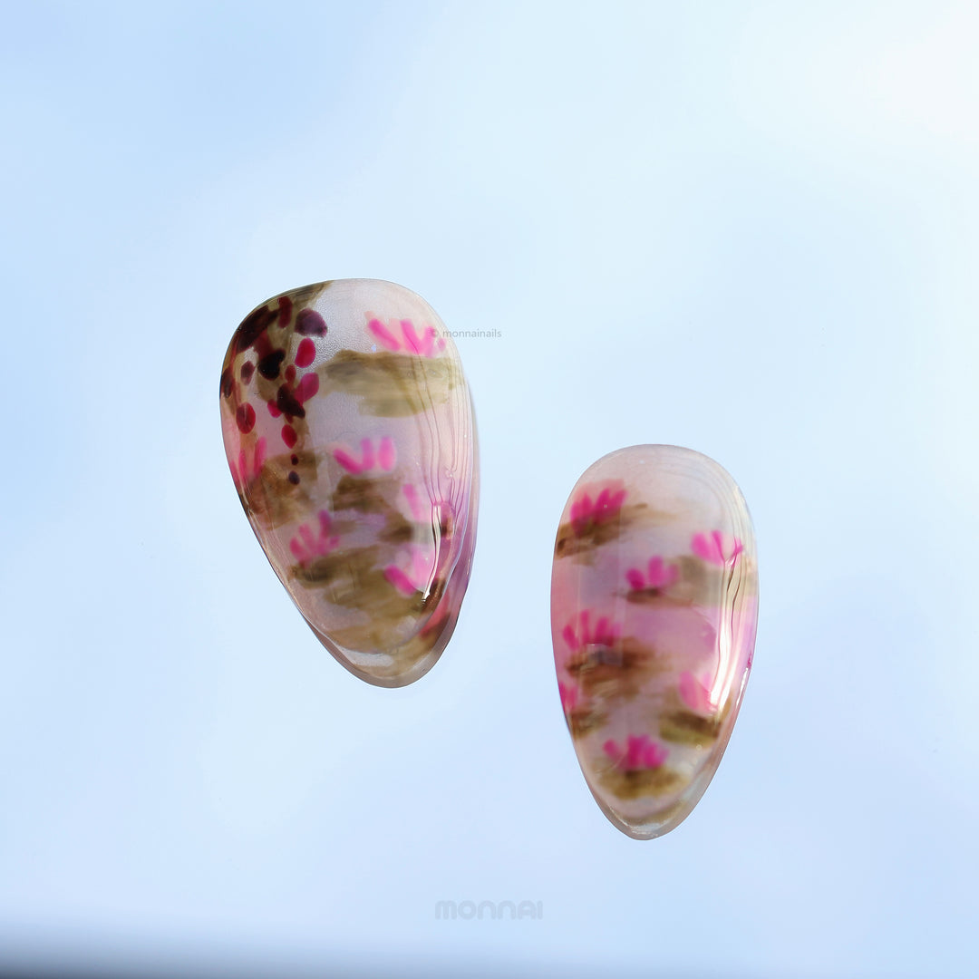 Water Lily Dream press-on nails laid out, with soft pink floral pond art, glossy depth and subtle shimmer.