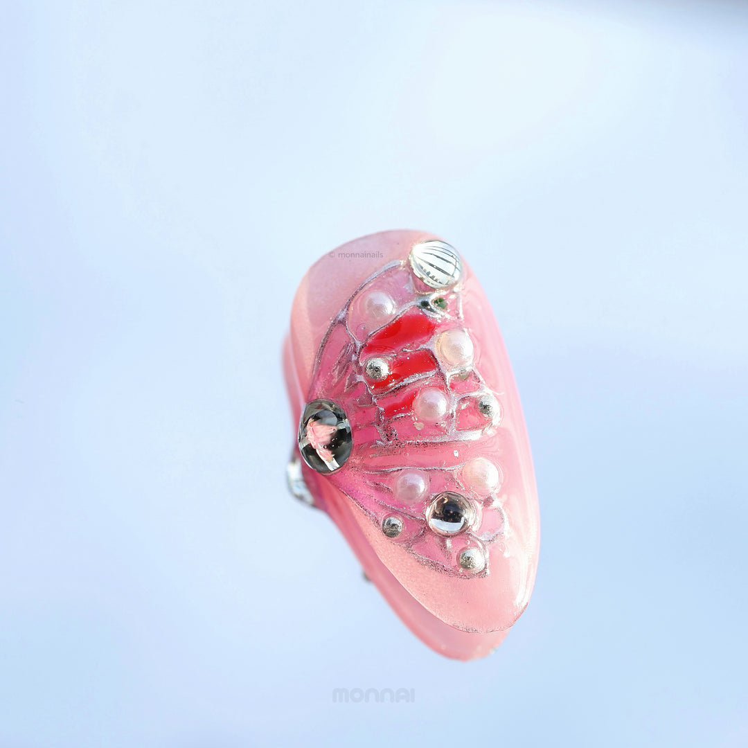 Water Lily Dream press-on nails in close-up, soft pink with glossy depth, shimmer, and sculpted bead details.