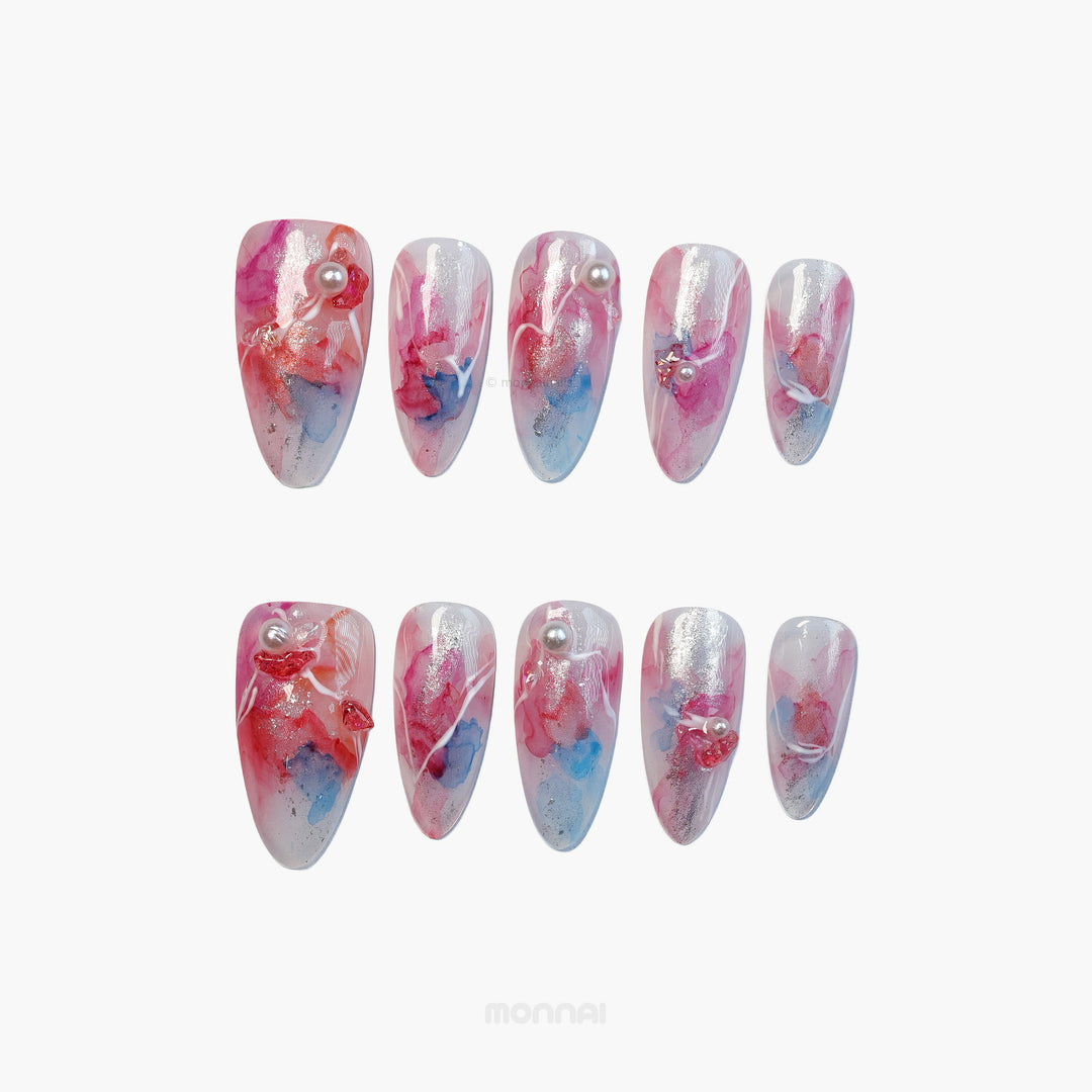 Whimsical Splash press-on nails with pink and blue watercolor marble, silver accents, pearls, and white linework.