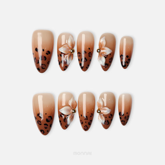 Wild Charm press-on nails with brown leopard print tips and white floral accents, shown in a laid-out set