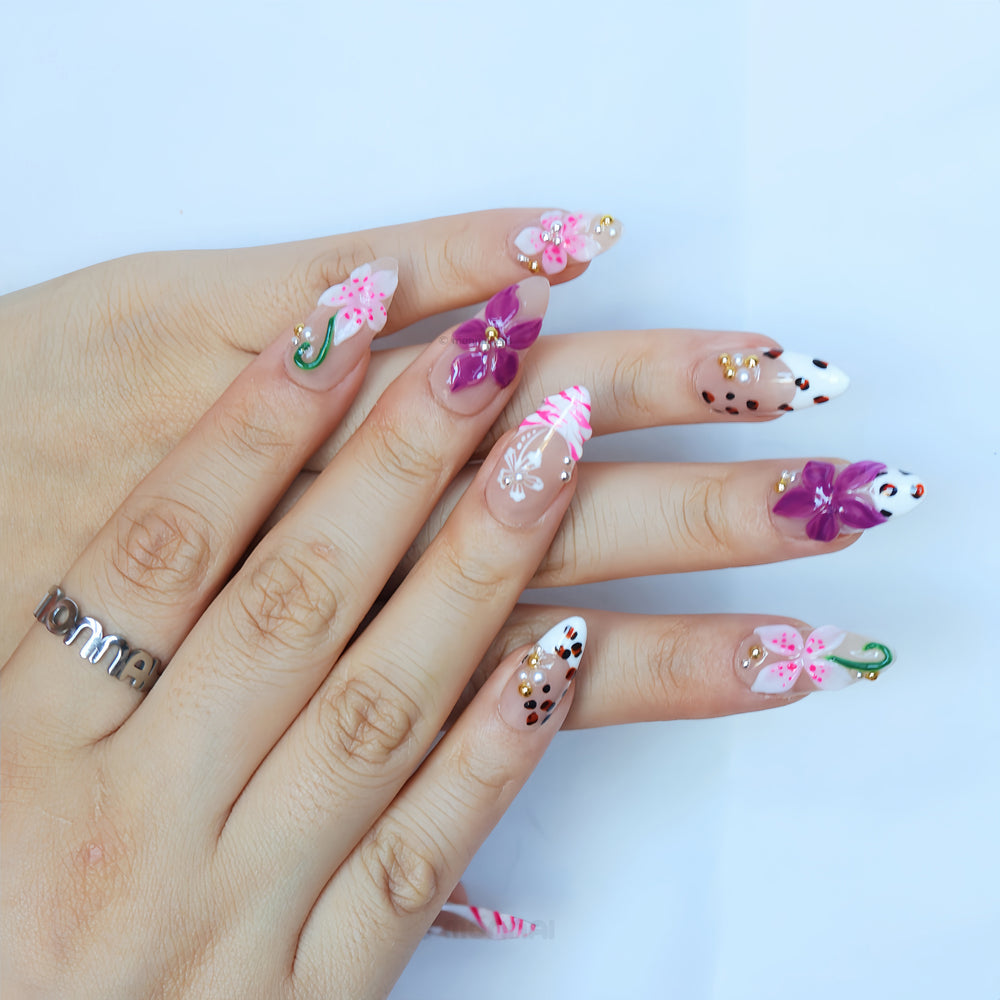 Wild Things press-on nails worn on hand with nude bases, pink and plum 3D flowers, leopard print and rhinestones
