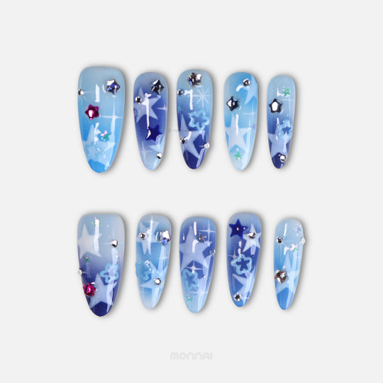 Wishing Jar press-on nails in a dreamy night sky gradient with star charms and rhinestones, laid out in blue and navy.