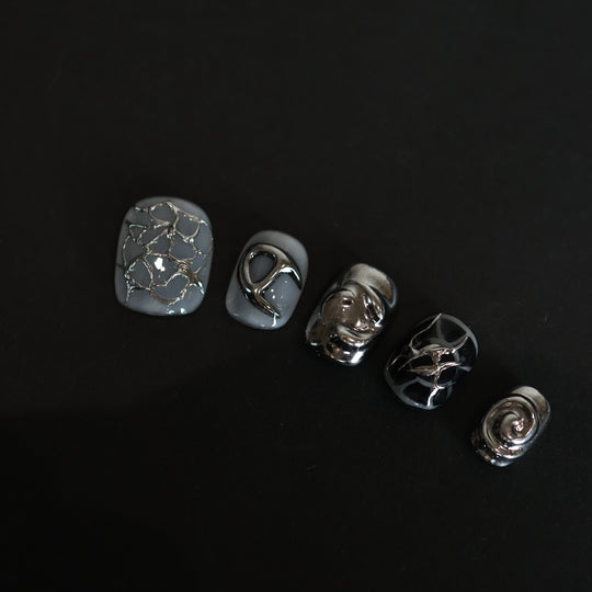 X-Edge press-on nails laid out in close-up, monochrome cybercore and grunge design with liquid metal chrome, crackle textures