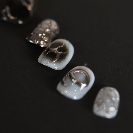 X-Edge press-on nails in close-up, monochrome cybercore rebellion with liquid metal chrome lines and high-gloss finish