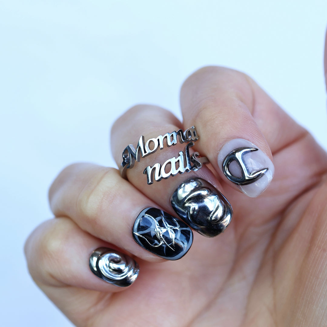 X-Edge cybercore grunge press-on nails with monochrome chrome 3D metal details shown worn on hand