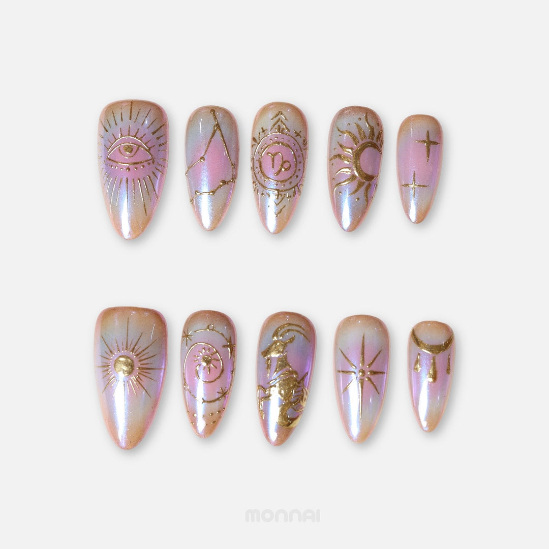 Capricorn press on nails from the Zodiac Collection, featuring iridescent pink tones, gold celestial motifs, constellation details and Capricorn symbols.