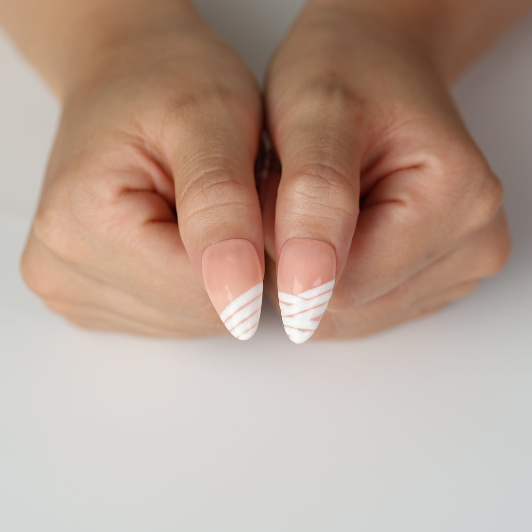 Peekaboo Mummy press-on nails on hands with nude gloss and white bandage stripes