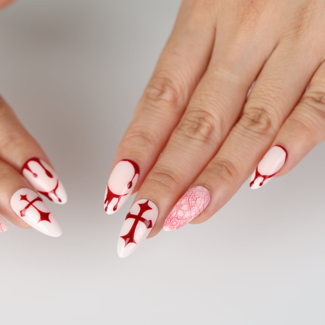 Blood Lace press-on nails on hand, pink base with red cross, dripping and lace designs